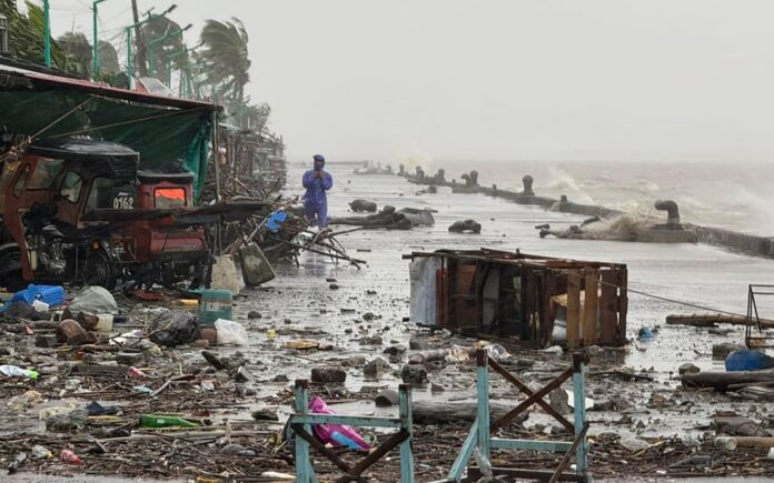 A man stands near debris amid heavy rain due to Super Typhoon Ragasa in Aparri town, Cagayan province on 22 September 2025. Photo: John Dimain / AFP